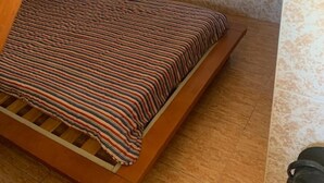 A small, sloped ceiling bedroom with a bed, a wooden bench, and a small window. - Sleeps2-freeparking-walktobeach-carvoeiro (Lagoa)
