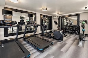 A gym with treadmills, a stationary bike, and a weight rack.