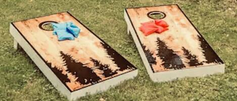 Two wooden planters with a blue and red cloth on a grassy area.