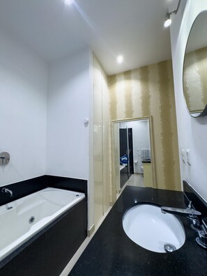 Een moderne badkamer met een badkuip, een wastafel en een spiegel.