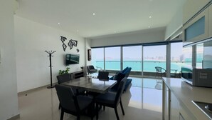 Un espace repas moderne avec une grande table, des chaises et un téléviseur fixé au mur.