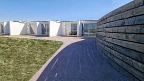 Un bâtiment moderne avec un chemin de gravier menant à une clôture en bois.