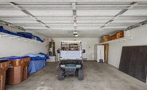 Een garage met een voertuig, opbergkisten en planken.