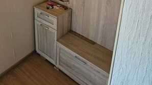 Ein Eckzimmer mit Kleiderschrank, kleinem Tisch und Spiegel.