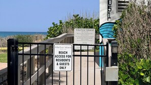 Une entrée fermée par un portail mène à un club de plage, et une pancarte indique que l’accès à la plage est réservé aux résidents et à leurs invités.