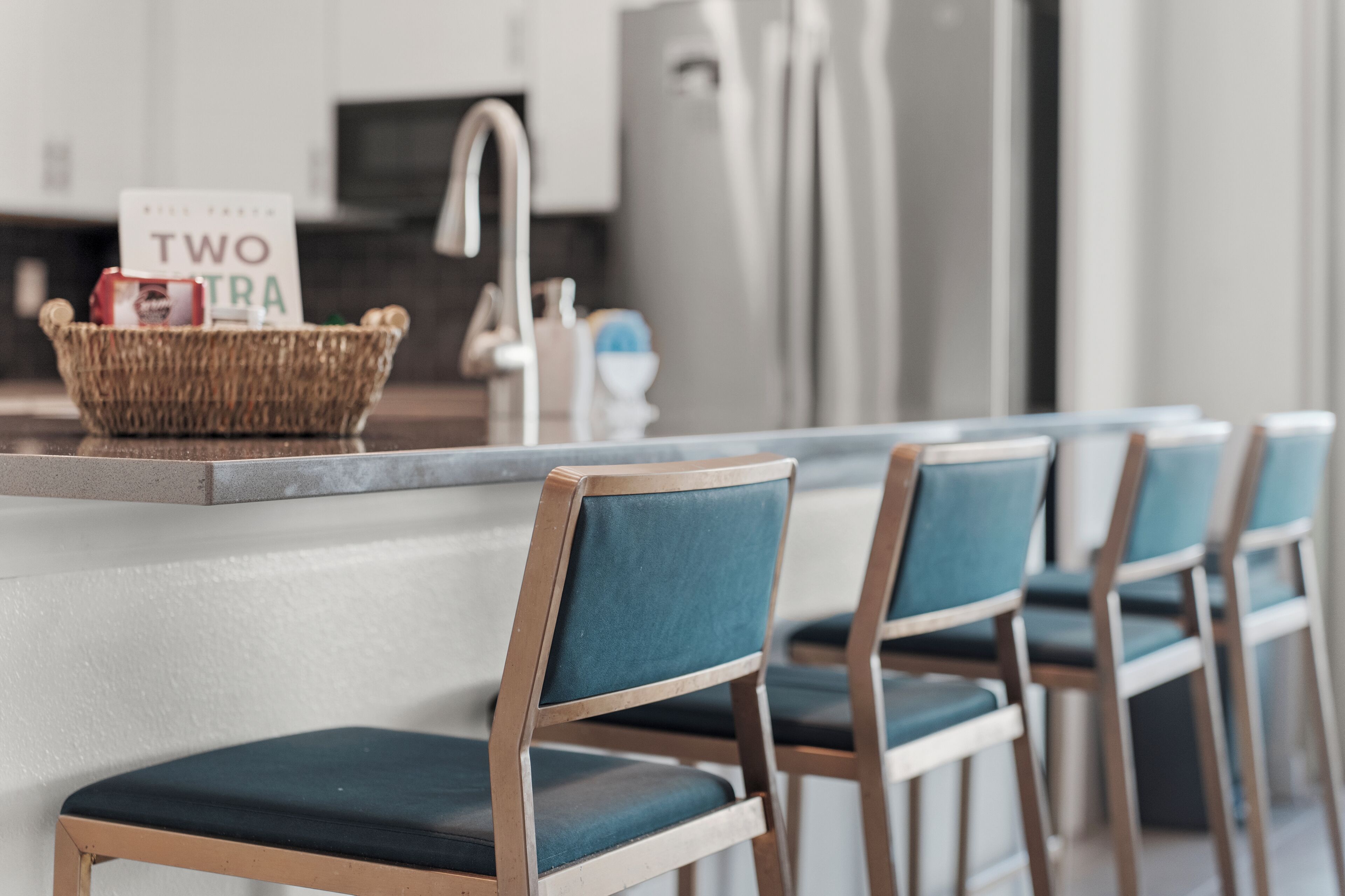 A kitchen with a counter, a basket, and a sign that reads 'TWO EXTRA'.