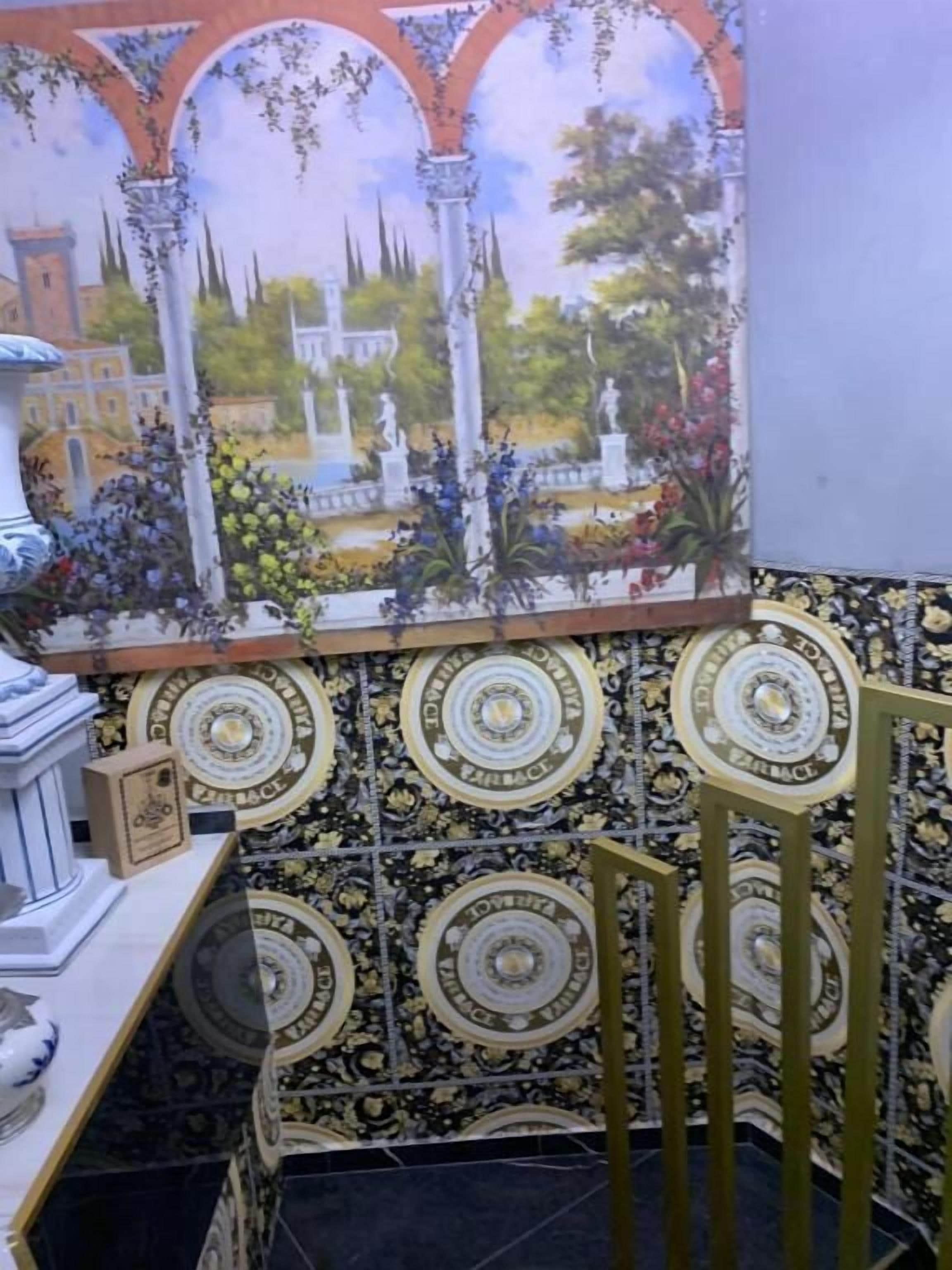 Ein Zimmer mit Fliesenwand, einer Zierrelung und einem Gemälde einer Fontäne.