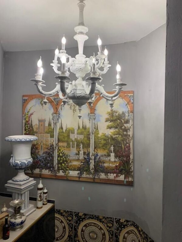 A room with a chandelier, a painting, and a tiled floor. - bristol palace (Rodigo)