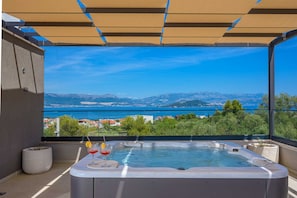 Ein Whirlpool mit Blick auf einen See und Berge.
