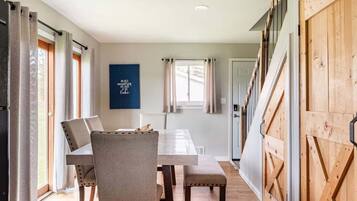 Un espace repas comprenant une table, des chaises et un panneau fixé au mur.