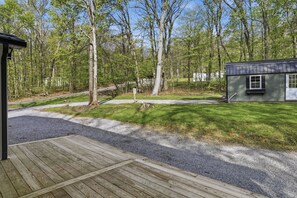 A wooden deck leading to a gravel path, surrounded by a forested area with a small building. - Doodle's Mountain Cape - Raystown Lake - Aunt Susie's (James Creek)
