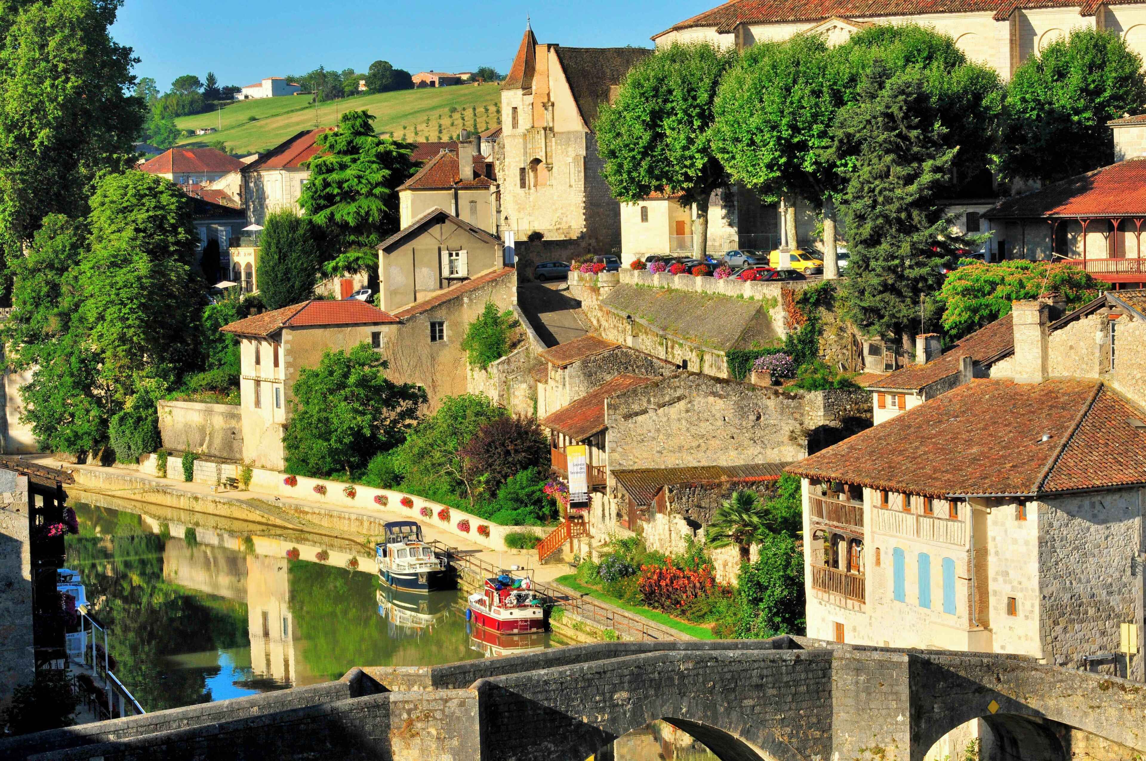 Un pueblo histórico con edificios de piedra, un canal y un puente.