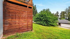A wooden fence, a well-maintained lawn, and a house with a garage.