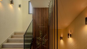 Portaikko, jossa on puiset ovet, ja ovissa lukee teksti ”VILLA ISABEL”, sekä maljakko, jossa on kasvi.
