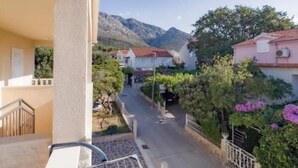 Una calle residencial con casas, una montaña al fondo y un cielo despejado.