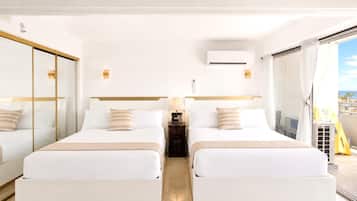 A hotel room with two beds, a large mirror, an air conditioning unit, and a balcony with a view.