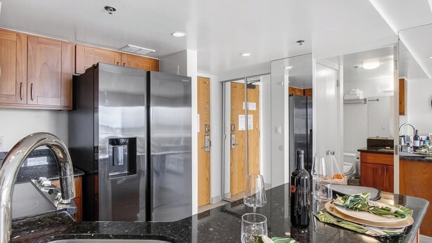 Une cuisine moderne dotée d’appareils électroménagers en acier inoxydable, d’un plan de travail en granit et de meubles en bois.