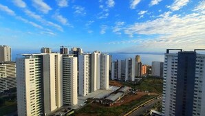 Un complejo de edificios residenciales de gran altura, con varias plantas, vista al mar y cielo despejado.