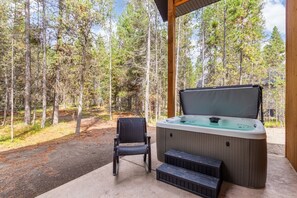 Ein Whirlpool mit Stufen, einem Sitzplatz und Blick auf einen Wald.