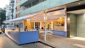 En restaurang med uteservering, ett överbyggt område och en väl synlig entré.