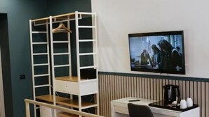 A bedroom with a bed, a desk, a chair, a TV, and a wardrobe. - Palazzo Ferrara  (Naples)
