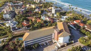 Eine Luftaufnahme einer Küstenstadt mit einer Mischung aus Wohn- und Geschäftsgebäuden, einer markanten Kirche und einem Strand.