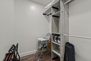 A compact room with a wooden wardrobe, a folding chair, and a black bag. - River House in Fennville (Fennville)