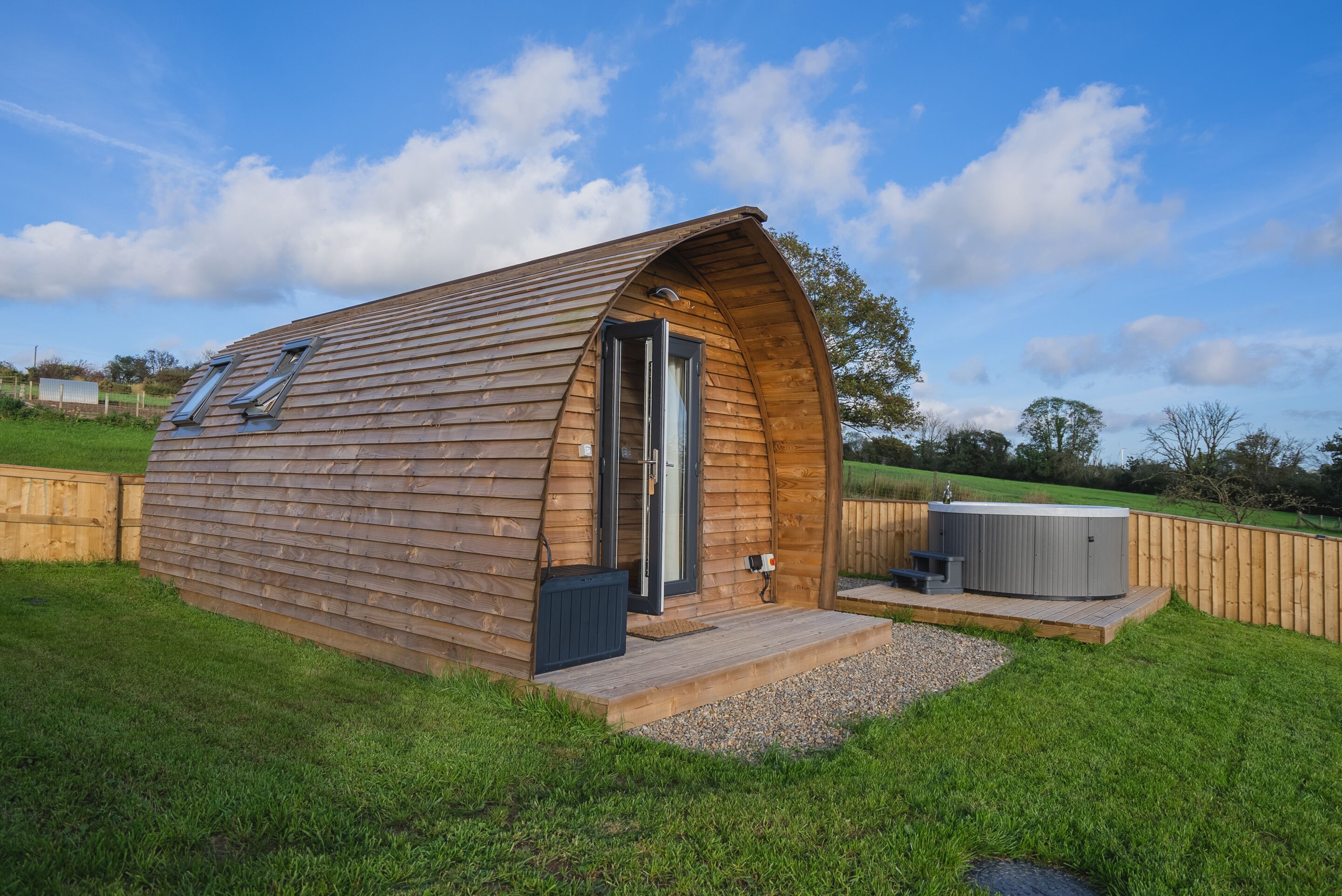 Une cabane en bois avec un toit en pente, une porte et une petite terrasse.