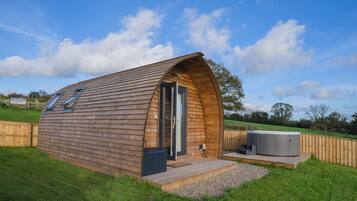 Une cabane en bois avec un toit en pente, une porte et une petite terrasse.