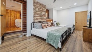 Une chambre à coucher avec un lit, un ventilateur de plafond et un mur en bois.