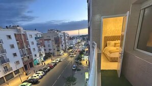 Un balcón con vistas a una calle urbana al anochecer.