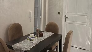 Un comedor con una mesa, sillas, una araña y una puerta.