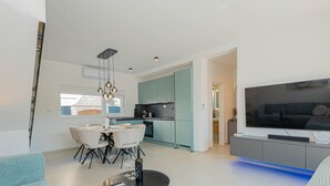 A modern living room with a TV, sofa, and dining area. - Villa Pomalo (Vodice)