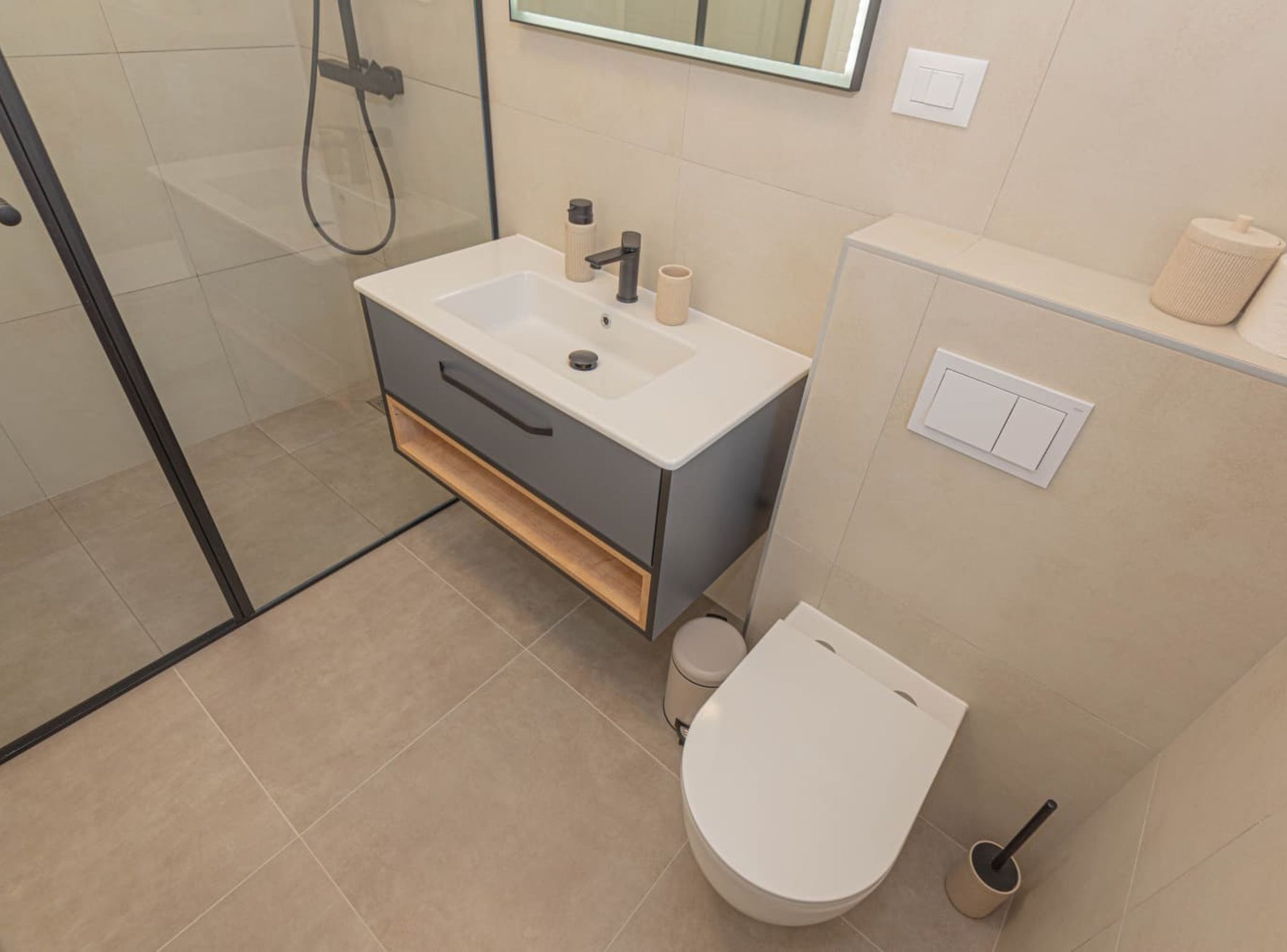 Une salle de bain moderne équipée d’une douche, de toilettes et d’un lavabo.