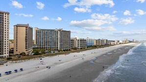 A beachside hotel with multiple high-rise buildings, a sandy beach, and ocean views. - Luxury Beachfront Condo: King Suite in Premier Location in North Myrtle Beach (North Myrtle Beach)