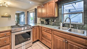 A kitchen with wooden cabinets, a stainless steel sink, and a built-in oven. - Spacious, Cozy 3 Bedroom 2 bath North End Home (Tacoma)
