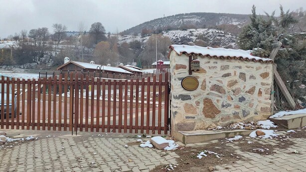 A stone building with a metal gate, surrounded by snow-covered ground and a hilly landscape. - Philomelion Lodge (Aksehir)