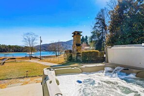 Un jacuzzi con vista a un lago y una torre de piedra.