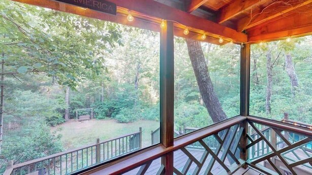 Una terraza de madera con vista a un área boscosa.