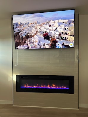 Ein Flachbildfernseher an der Wand über einem Kamin.