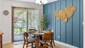 A dining area with a round table, four chairs, a clock, and a decorative wall piece. - Quiet retreat, spacious living and dining (Sioux Falls)