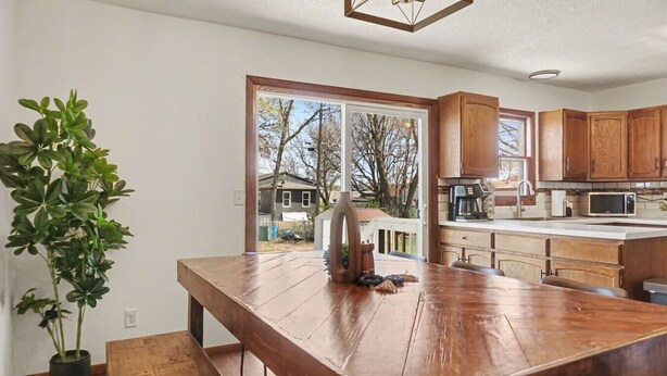 Een keuken met houten kasten, een groot eiland en een kamerplant.