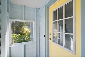 A door with a window, a yellow wall, and a light blue exterior. - Charming Seaside Cottage in Victoria's Historic Core (Victoria South)