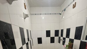 Un baño con piso a cuadros, un inodoro, un lavamanos y un espejo.