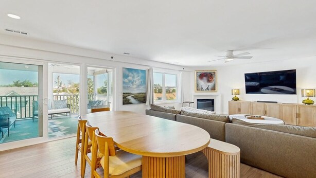 A modern living room with a large round table, a sofa, and a television. - Rehoboth Beach - 24 Brooklyn Ave Unit E (Rehoboth Beach)