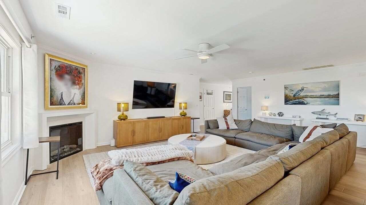A spacious living room with a fireplace, a large flat-screen TV, and a comfortable seating area.