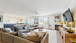 A modern living room with a sofa set, a coffee table, and a TV. - Rehoboth Beach - 24 Brooklyn Ave Unit E (Rehoboth Beach)