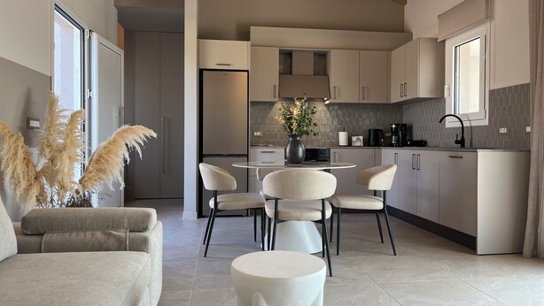 Een moderne keuken met een eethoek, met een ronde tafel, stoelen en een bank.