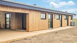 A modern wooden building with multiple doors and windows, a flat roof, and an air conditioning unit. - Amazing home in Vestervig with WiFi (Vestervig)