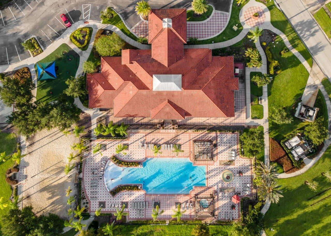 Vue aérienne d’un hôtel doté d’une piscine, d’un espace couvert avec des sièges et d’un parking.